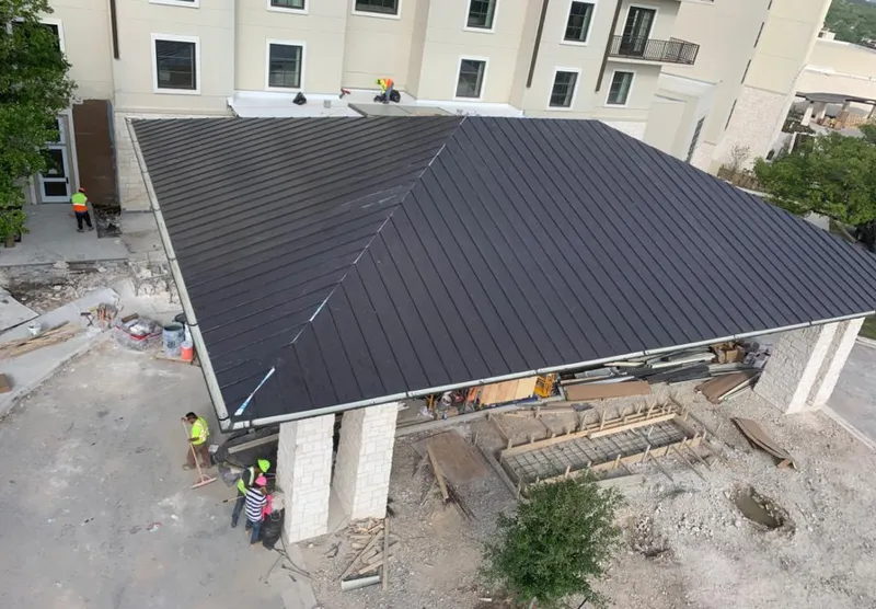 Metal roofing installation team working on a commercial building in Tisbury